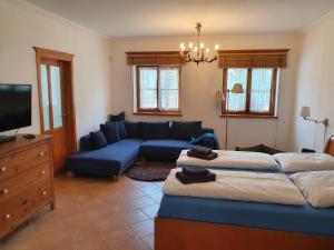 a living room with two beds and a blue couch at Landhaus Steirerengel in Lócs