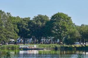 a boat is docked at a dock on a lake at Doppelzimmer mit kleiner Pantryküche Gästehaus Unter den Linden in Mühbrook