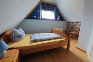 a small bedroom with a bed and a window at Uns Muschelhus in Zingst