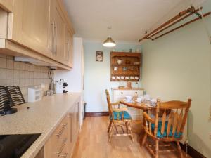 a kitchen with a table and two chairs at 1 The Gardens in Stowmarket