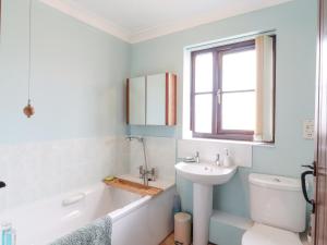 a bathroom with a sink and a tub and a toilet at 1 The Gardens in Stowmarket +20 photos