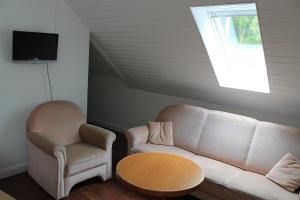 a living room with a couch and a chair and a table at Hotel Restaurant Neu-Holland in Kassel