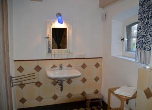 ein Bad mit einem Waschbecken und einem Spiegel in der Unterkunft Stallteil in Oldsum