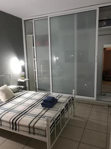 uma cama num quarto com uma grande janela em Cozy 1 bedroom apartment close to the beach em Pafos