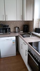 Una cocina con gabinetes blancos y un fregadero. en Fewo 91 WHG B 9 in Burhave, en Burhave