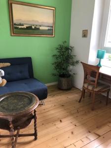 un soggiorno con divano blu e tavolo di La Maison des Copains a Blonay