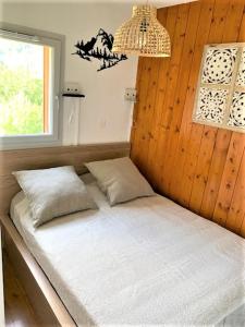a bed with two pillows in a room with a window at Appartement tt confort au coeur des montagnes vue sur les montagnes II Wifi in Luz-Saint-Sauveur
