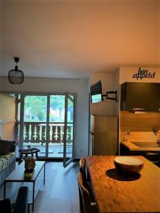 a living room with a table and a kitchen at Appartement tt confort au coeur des montagnes vue sur les montagnes II Wifi in Luz-Saint-Sauveur