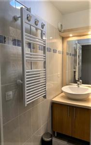 a bathroom with a sink and a mirror at Appartement tt confort au coeur des montagnes vue sur les montagnes II Wifi in Luz-Saint-Sauveur