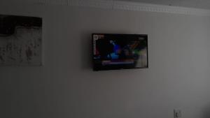 a flat screen tv hanging on a white wall at 81 Pool Room cottage house in Durban