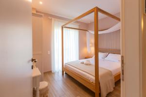ein Schlafzimmer mit einem Himmelbett in einem Zimmer in der Unterkunft Two Olive Trees - Deluxe Apartments in Psathopyrgos
