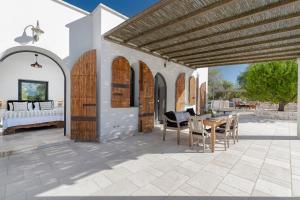 a patio with a bed and a table and chairs at Cisternino Villa in Olive Groove in Cisternino