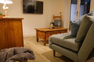 a living room with a couch and a table at Sennen Cove Retreat in Sennen Cove