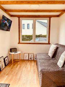 uma sala de estar com uma cama e uma janela em TINY HOUSE FLEESENSEE mit eigenem Garten und nur wenige Meter vom Seeufer em Göhren-Lebbin