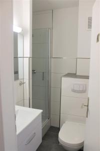 een witte badkamer met een toilet en een douche bij Haus Barbara - Schwimmbad und Sauna im Haus- Whg 7 in Grömitz