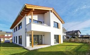 a white house with a gambrel roof at Chalethaus-Chiemsee - 120qm Panorama-Chaletwohnung am Chiemsee - Neubau in Prien am Chiemsee