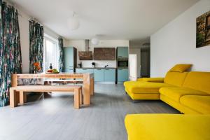 ein Wohnzimmer mit einem gelben Sofa und einem Tisch in der Unterkunft Apartment by Janzen E in Rheine