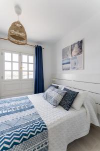 El Muellito Ocean View في بونتا موخيريس: غرفة نوم بسرير وبطانية زرقاء وبيضاء