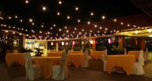 un salón de banquetes con mesas, sillas y luces en Straits View Hotel JB en Johor Bahru