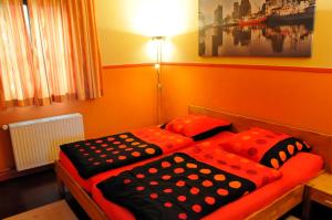 2 Einzelbetten in einem Zimmer mit orangefarbenen Wänden in der Unterkunft Fischerhaus am Binnensee in Heiligenhafen