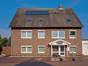 a brick house with solar panels on the roof at Gästehaus Passat in Niendorf