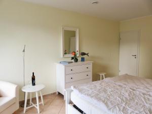 a bedroom with a bed and a dresser and a mirror at Lindenstraße 43, Whg 1 - Nord bei Nordost in Zingst