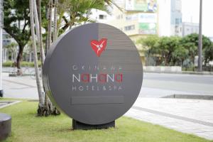 a sign for a hotel in a park at Okinawa NaHaNa Hotel & Spa in Naha