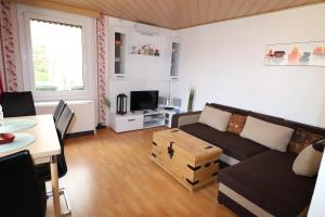 ein Wohnzimmer mit einem Sofa und einem Tisch in der Unterkunft Haus am See - KEK2 in Tanna