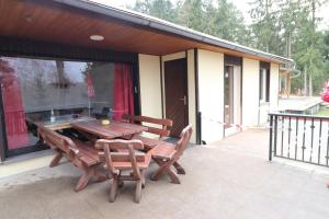 einen Holztisch und zwei Stühle auf einer Terrasse in der Unterkunft Haus am See - KEK2 in Tanna