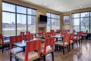 a dining room with tables and chairs and windows at Comfort Suites Jonesboro University Area in Jonesboro