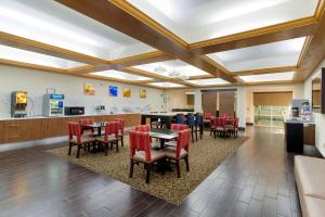 une salle à manger avec des tables et des chaises ainsi qu'une cuisine dans l'établissement Comfort Suites Milledgeville, à Milledgeville