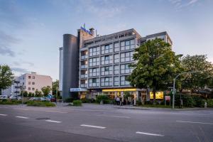 a building on a city street with a street at Comfort Hotel Atlantic Muenchen Sued in Ottobrunn
