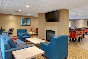 a waiting room with blue chairs and a fireplace at Comfort Inn East Pickerington in Pickerington