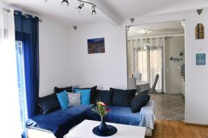 - un salon avec un canapé bleu et une table dans l'établissement Apartman SÙŠANJ, à Opatija