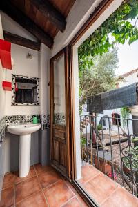 een badkamer met een wastafel en een glazen schuifdeur bij Amaka House in Granada