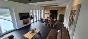 a living room with a couch and a table with chairs at Upland View in Willingen