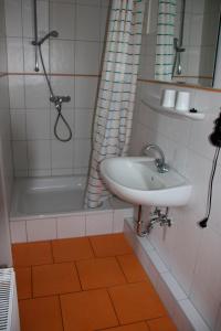 y baño con lavabo, ducha y bañera. en Ferienwohnung "Möwennest", en Hinrichsdorf