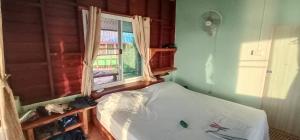 ein kleines Schlafzimmer mit einem Bett und einem Fenster in der Unterkunft KohChangResortRanong in Koh Chang Ranong