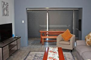 ein Wohnzimmer mit Klavier und Couch in der Unterkunft Gable Cottages 3 in Clarens