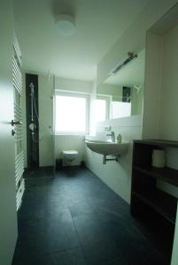 a bathroom with a sink and a toilet and a window at Eschbach in Bettnau