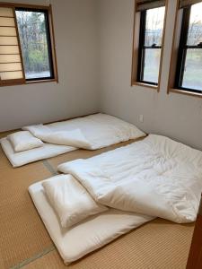 那須塩原市にある民宿　道の2つの窓がある部屋の白いベッド3台