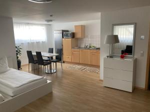 ein Zimmer mit einem Bett und eine Küche mit einem Tisch in der Unterkunft By Stelwag in Bermatingen