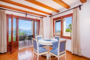 Un comedor con mesa y sillas y un balcón. en Gran Vista Mar, en Alcudia