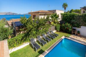 a backyard with a swimming pool and chairs at Gran Vista Mar in Alcudia