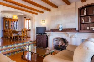 Una sala de estar con chimenea y una mesa. en Gran Vista Mar, en Alcudia