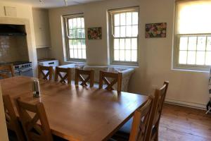 une salle à manger avec une grande table et des chaises en bois dans l'établissement Hall Cottage, Wighill near York and Leeds, à Tadcaster