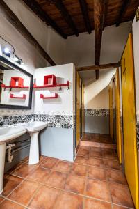 baño con 2 lavabos y estanterías rojas en Amaka House en Granada