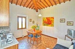een woonkamer met een tafel en een keuken bij Agriturismo Fattoria Il Piano - Appartamento Lavanda - San Gimignano in Borgatello