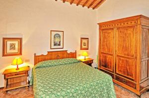 een slaapkamer met een groen bed en houten kasten bij Agriturismo Fattoria Il Piano - Appartamento Lavanda - San Gimignano in Borgatello