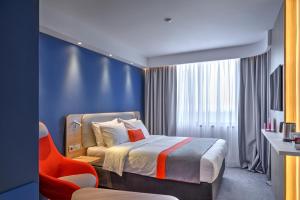 a hotel room with a bed and a chair at Holiday Inn Express - Almaty, an IHG Hotel in Almaty